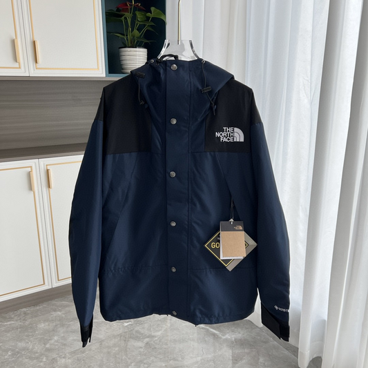 The North Face GORE-TEX Waterproof Hooded Mountain Jacket, Navy Blue and Black Colorblock Outdoor Windbreaker   再写一个包含品牌词的英文标题，突出夹克的保暖功能   写一个包含品牌词的英文标题，用于宣传北面冲锋衣的科技性能   请再写几个不同风格的包含品牌词的英文标题